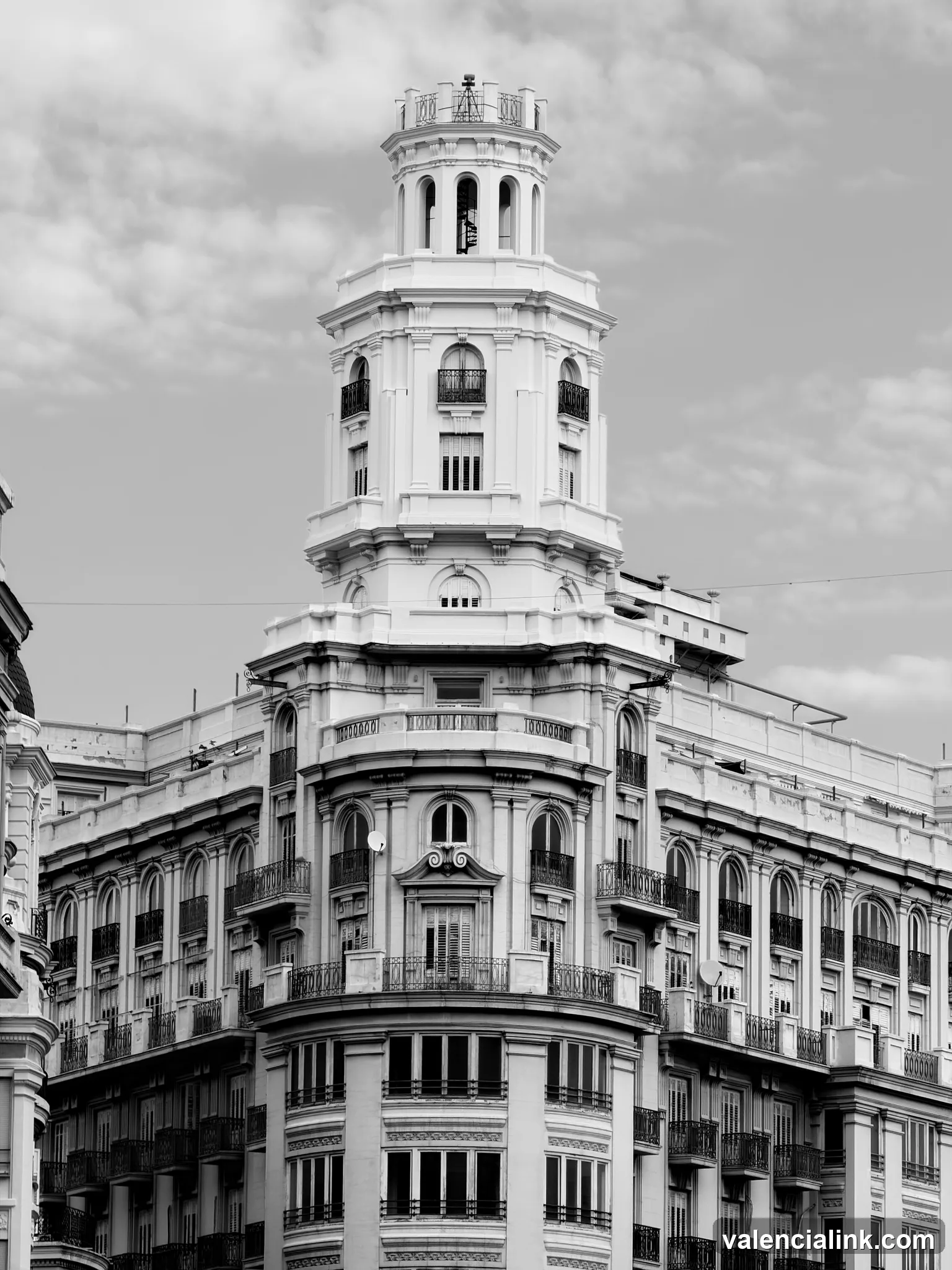 A black and white architectural photograph of a building with a tower and detailed facade.