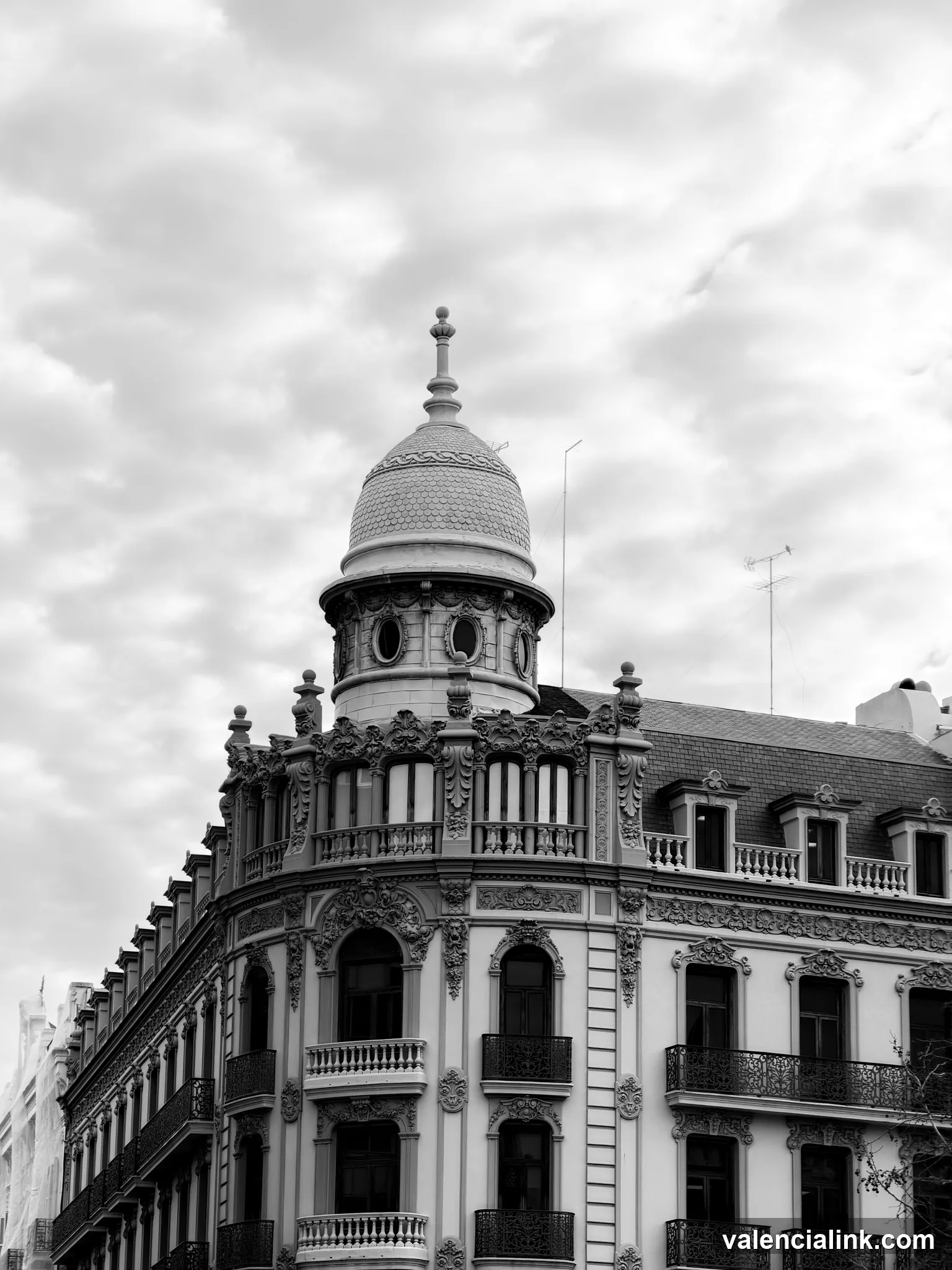 Black and white architectural details of a building with a dome and balconies.