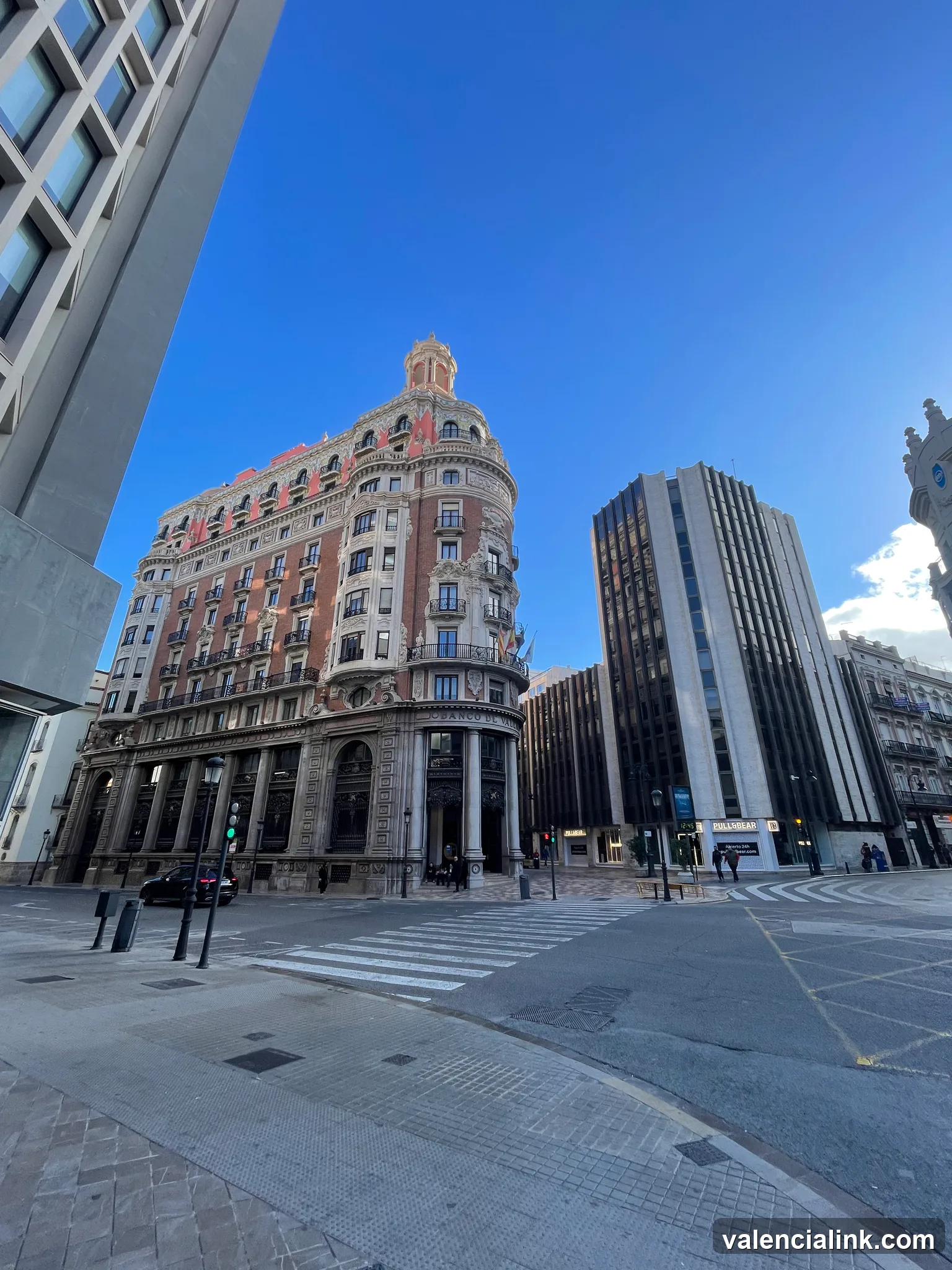 Historic building with ornate architecture in an urban setting under a clear blue sky.